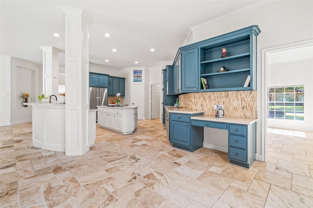 kitchen with tasteful backsplash, crown molding, built in desk, and blue cabinetry