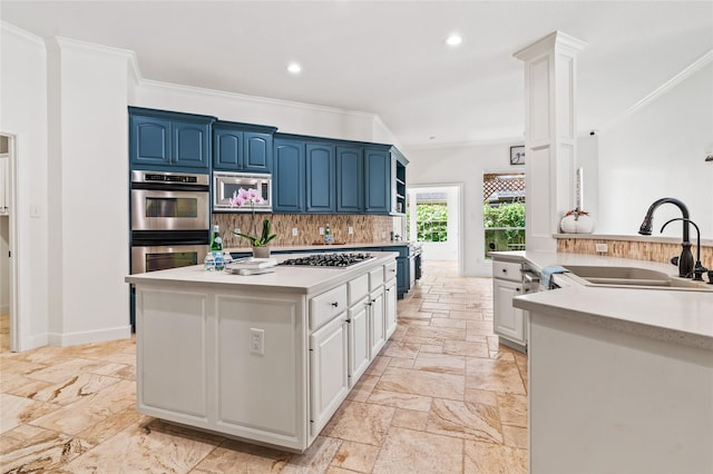 kitchen featuring blue cabinets, sink, ornamental molding, stainless steel appliances, and white cabinets