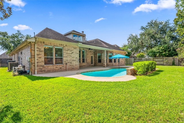 back of property with a fenced in pool, a patio area, ceiling fan, and a lawn