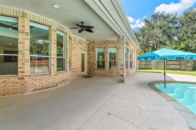 view of patio featuring ceiling fan and a fenced in pool