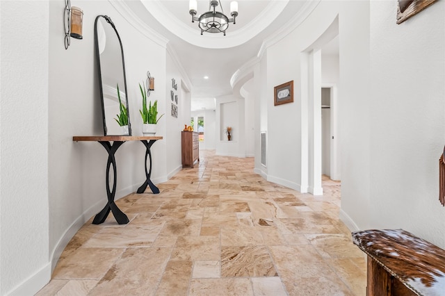 corridor with ornamental molding and a chandelier