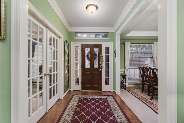 entrance foyer featuring crown molding, dark wood-type flooring, french doors, and a healthy amount of sunlight