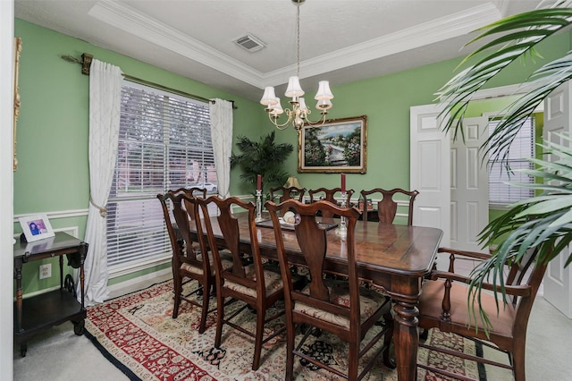 dining area featuring ornamental molding, a chandelier, carpet, and a raised ceiling