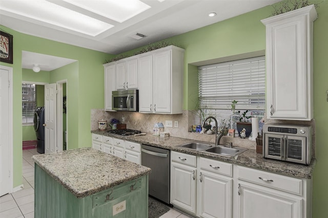 kitchen featuring appliances with stainless steel finishes, a kitchen island, and white cabinets