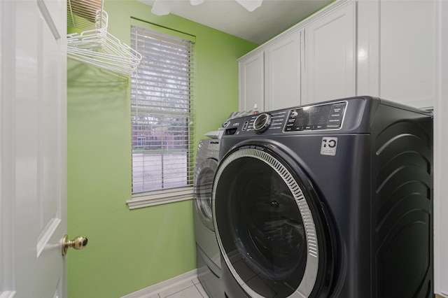 washroom with cabinets, a healthy amount of sunlight, and washing machine and dryer