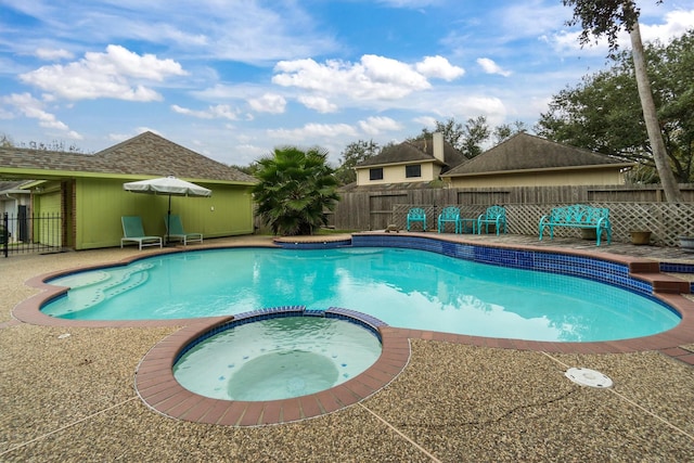 view of swimming pool with an in ground hot tub