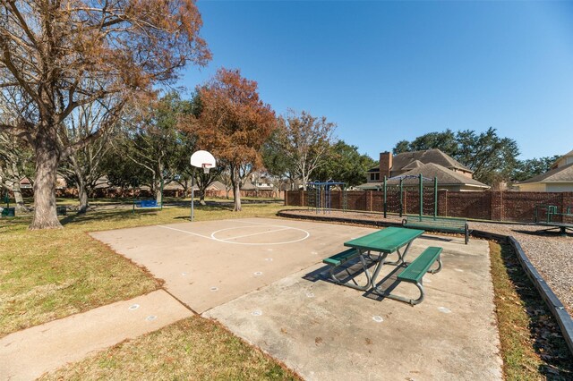 view of sport court with a playground and a yard