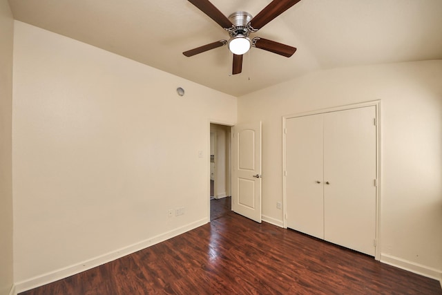 unfurnished bedroom featuring dark wood-type flooring, ceiling fan, vaulted ceiling, and a closet