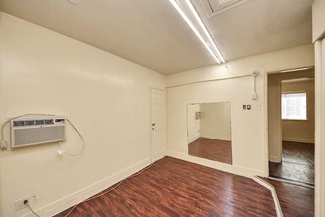 empty room featuring dark hardwood / wood-style flooring and a wall unit AC