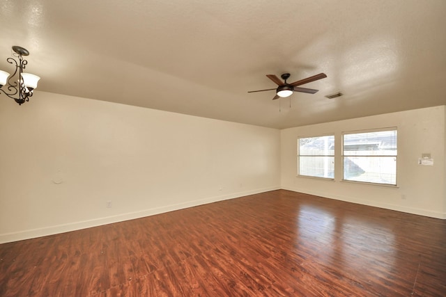 spare room featuring dark hardwood / wood-style flooring and ceiling fan with notable chandelier