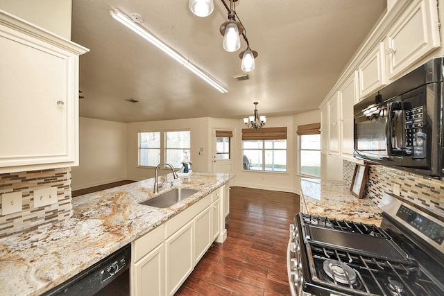 kitchen with black appliances, decorative light fixtures, tasteful backsplash, sink, and a chandelier