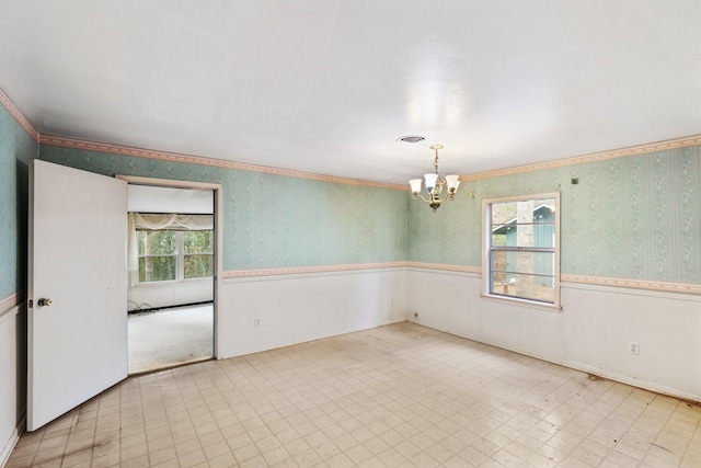 unfurnished room featuring a chandelier and ornamental molding