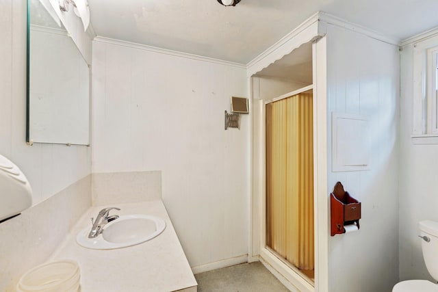 bathroom featuring toilet, vanity, a shower, and crown molding