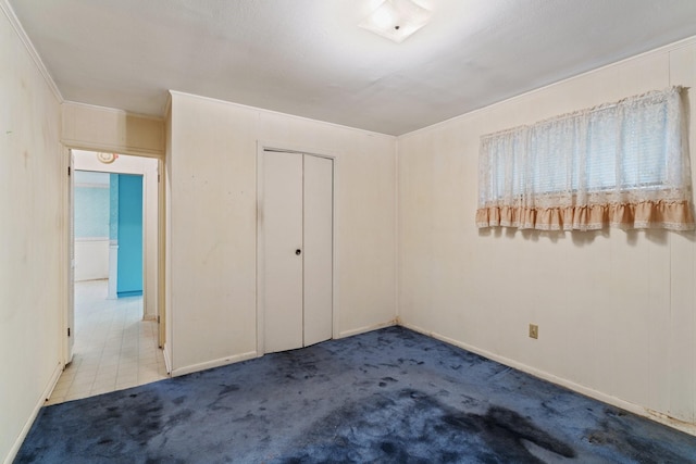 unfurnished bedroom with a closet and carpet flooring