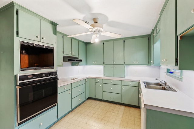 kitchen with ceiling fan, green cabinetry, sink, and oven