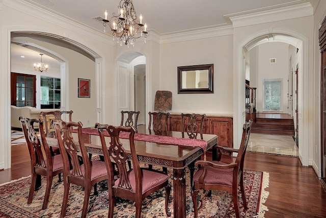 dining space featuring dark hardwood / wood-style flooring, crown molding, and a notable chandelier