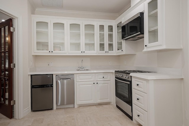 kitchen featuring sink, white cabinetry, appliances with stainless steel finishes, and crown molding