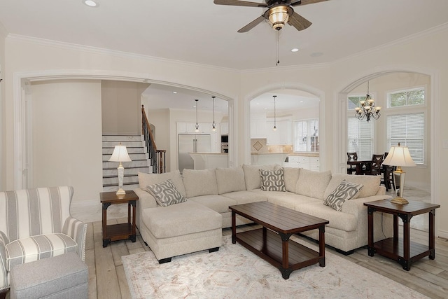 living room with plenty of natural light, ornamental molding, and light hardwood / wood-style flooring