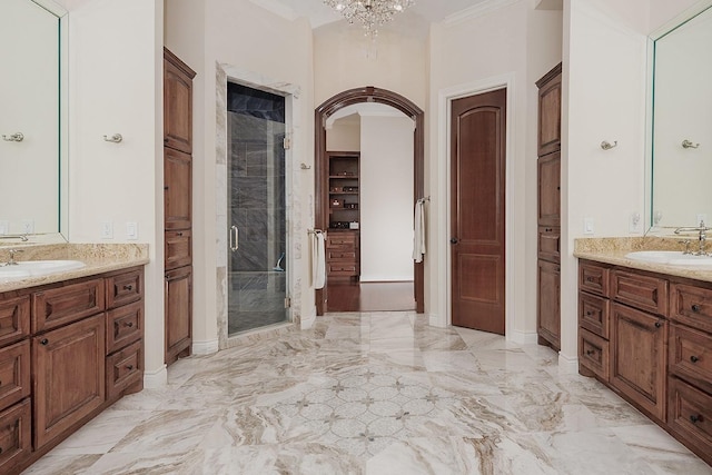 bathroom with crown molding, a shower with shower door, vanity, and a notable chandelier