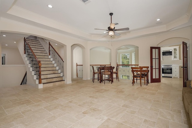 dining space featuring ceiling fan, ornamental molding, and a raised ceiling