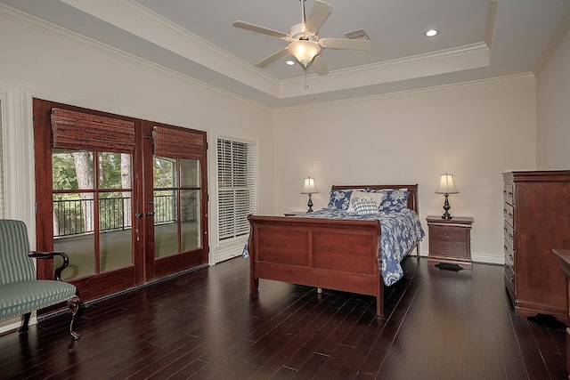 bedroom with ceiling fan, a raised ceiling, dark wood-type flooring, french doors, and crown molding