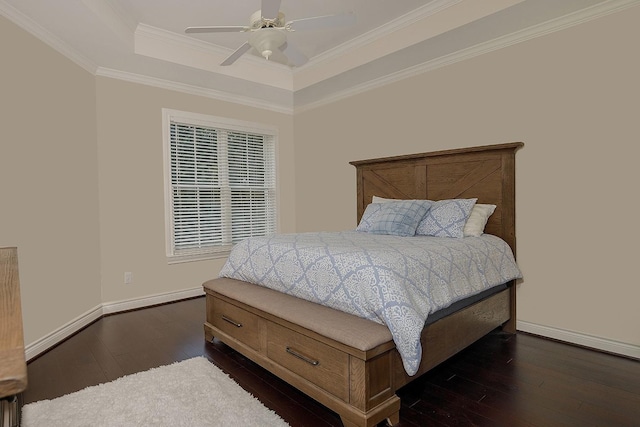 bedroom featuring ceiling fan, dark wood-type flooring, a tray ceiling, and ornamental molding