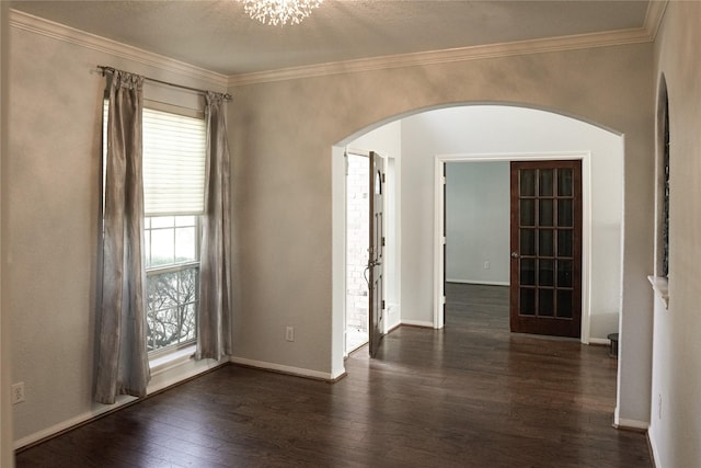 spare room featuring ornamental molding, dark wood-type flooring, and a textured ceiling