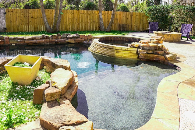 view of swimming pool featuring an outdoor fire pit, a garden pond, and a patio area