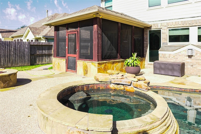 view of patio / terrace with a sunroom and an outdoor hot tub