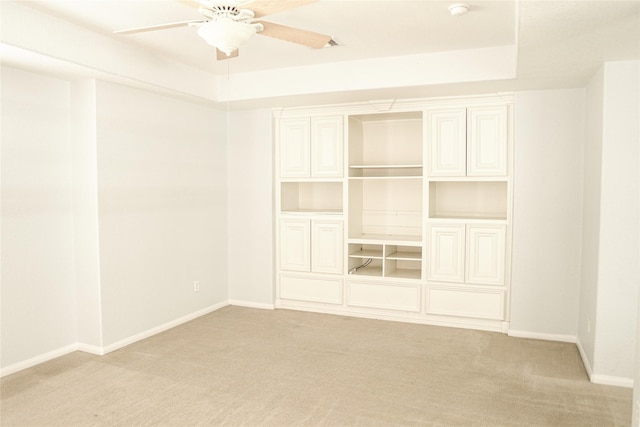 unfurnished bedroom featuring light colored carpet, a closet, ceiling fan, and a raised ceiling