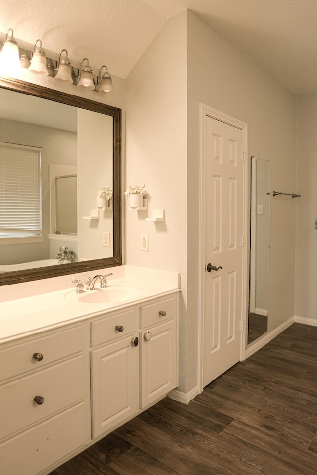 bathroom featuring vanity, vaulted ceiling, and hardwood / wood-style floors