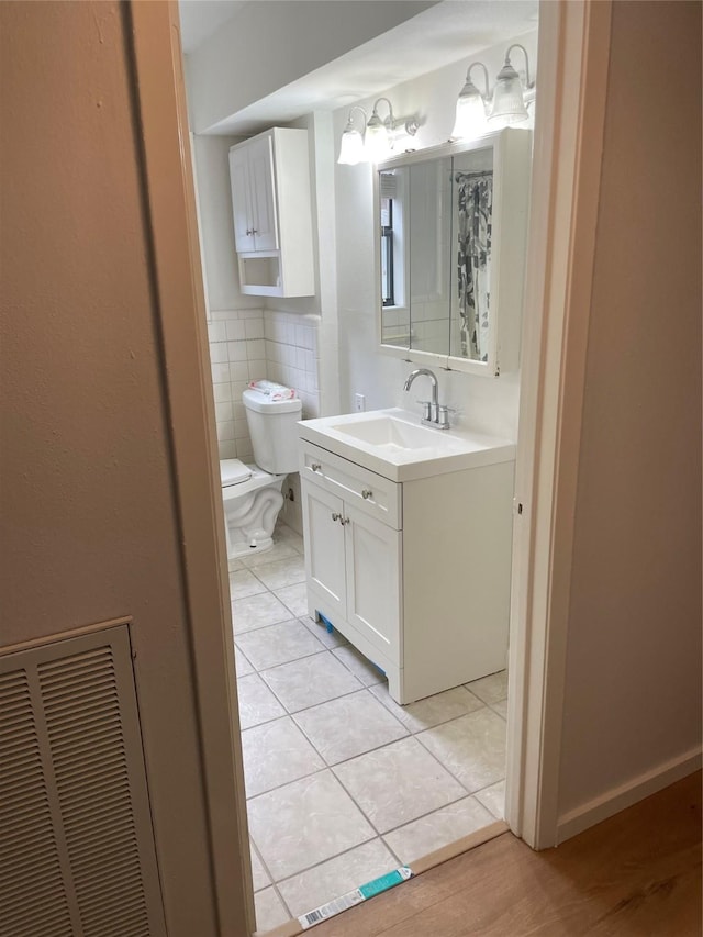 3809 N Braeswood Blvd Unit 24, Houston, TX 77025 - bathroom featuring decorative backsplash, toilet, vanity, and tile patterned flooring