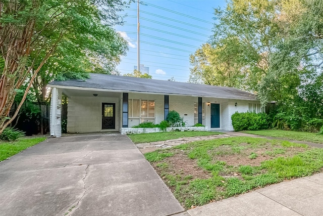 ranch-style home with a carport, a porch, and a front yard