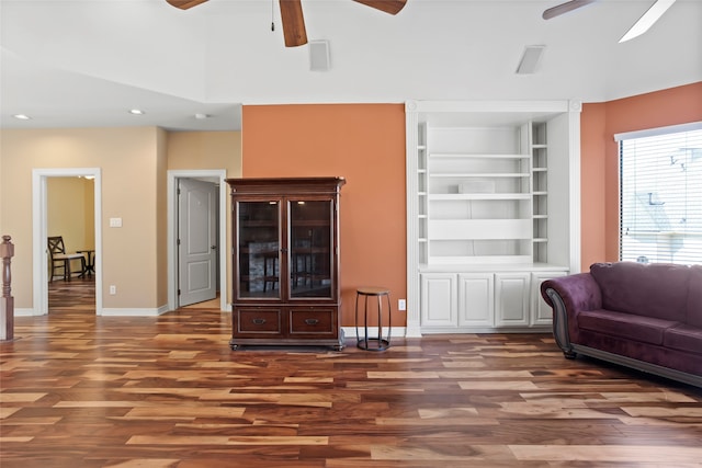 living room featuring dark wood-type flooring and built in features