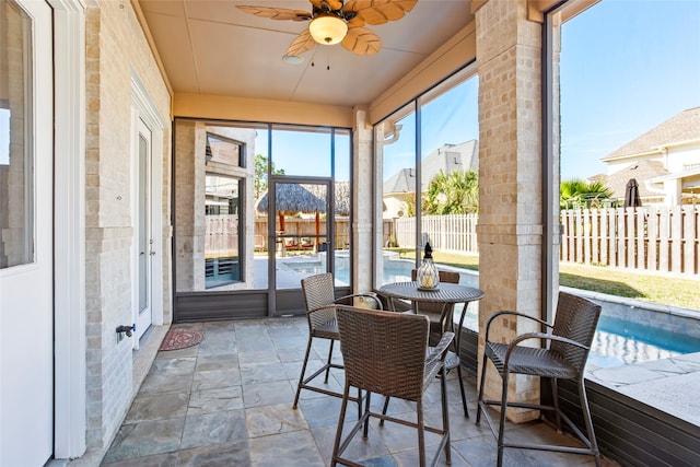 sunroom / solarium featuring ceiling fan