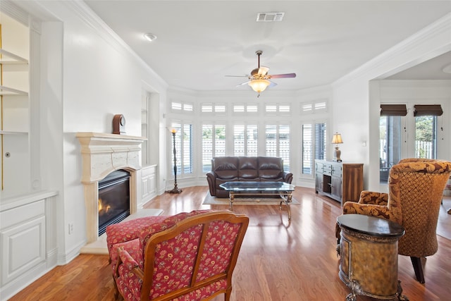 living room with ceiling fan, ornamental molding, and a healthy amount of sunlight