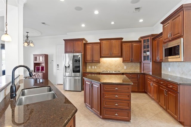 kitchen featuring stainless steel appliances, tasteful backsplash, a kitchen island, pendant lighting, and sink