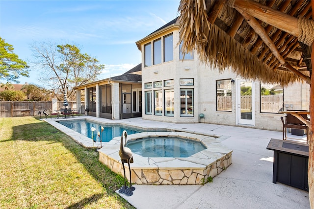 view of swimming pool with a patio area, a yard, and an in ground hot tub