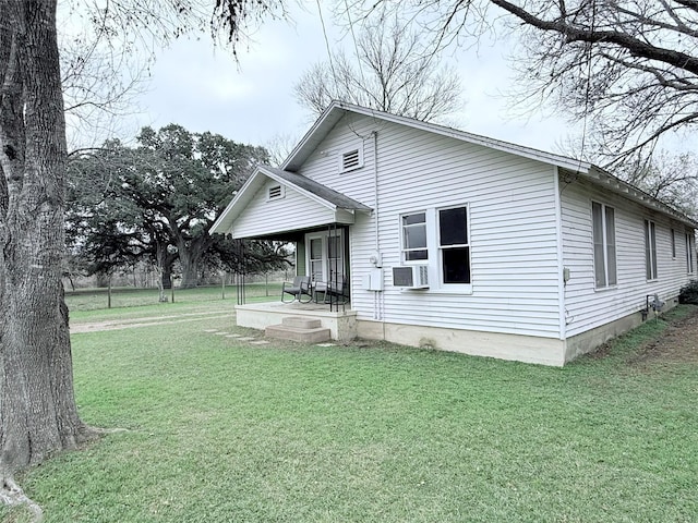 rear view of property with a yard, covered porch, and cooling unit