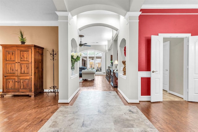 foyer entrance with hardwood / wood-style floors, ornamental molding, decorative columns, and ceiling fan