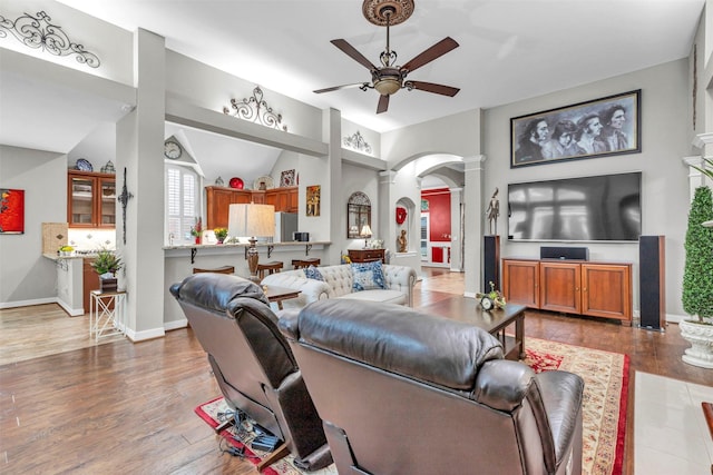 living room with decorative columns, wood-type flooring, and ceiling fan