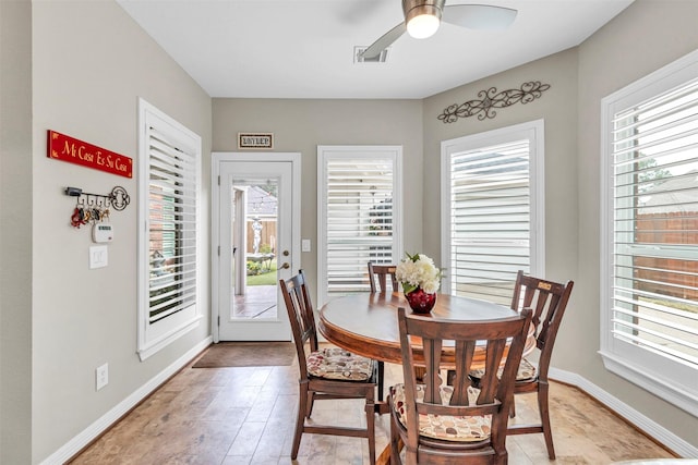 dining space with ceiling fan and light wood-type flooring