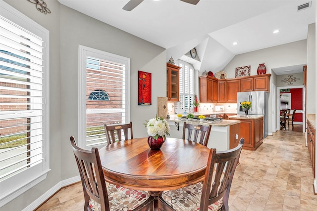 dining space with vaulted ceiling, plenty of natural light, and ceiling fan