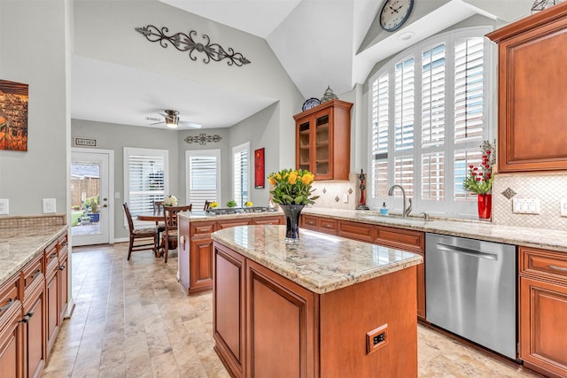 kitchen with light stone counters, sink, a kitchen island, and appliances with stainless steel finishes