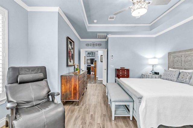 bedroom with a raised ceiling, crown molding, ceiling fan, and light hardwood / wood-style floors