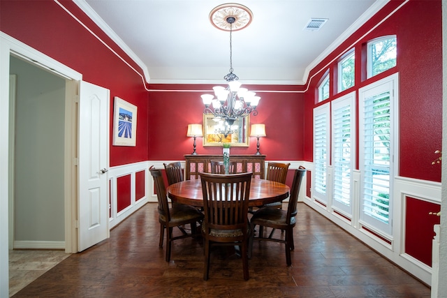 dining room with an inviting chandelier, crown molding, plenty of natural light, and dark wood-type flooring