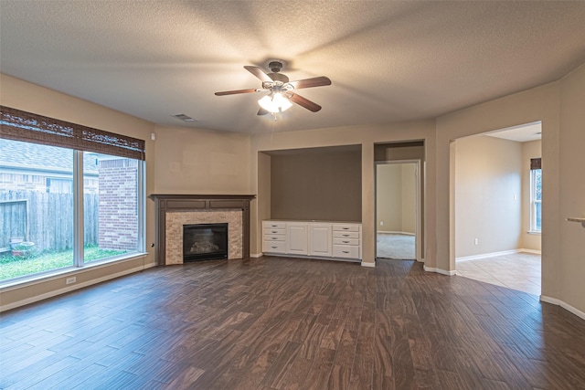 unfurnished living room featuring ceiling fan, a textured ceiling, and dark hardwood / wood-style floors