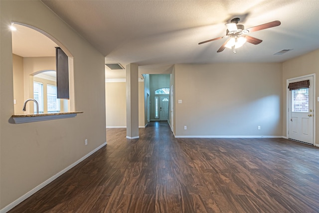 empty room with ceiling fan and dark hardwood / wood-style flooring