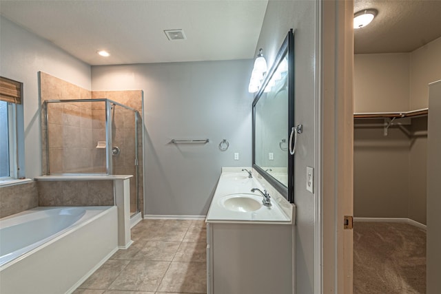 bathroom featuring a textured ceiling, independent shower and bath, tile patterned floors, and vanity