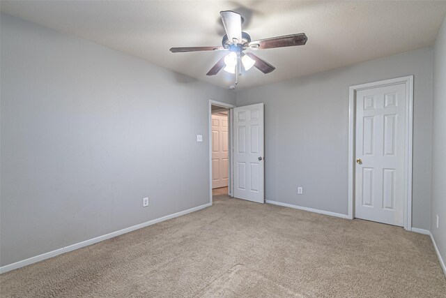 unfurnished bedroom with ceiling fan and light colored carpet